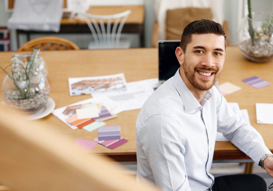 Young businessman sitting at desk and working in office